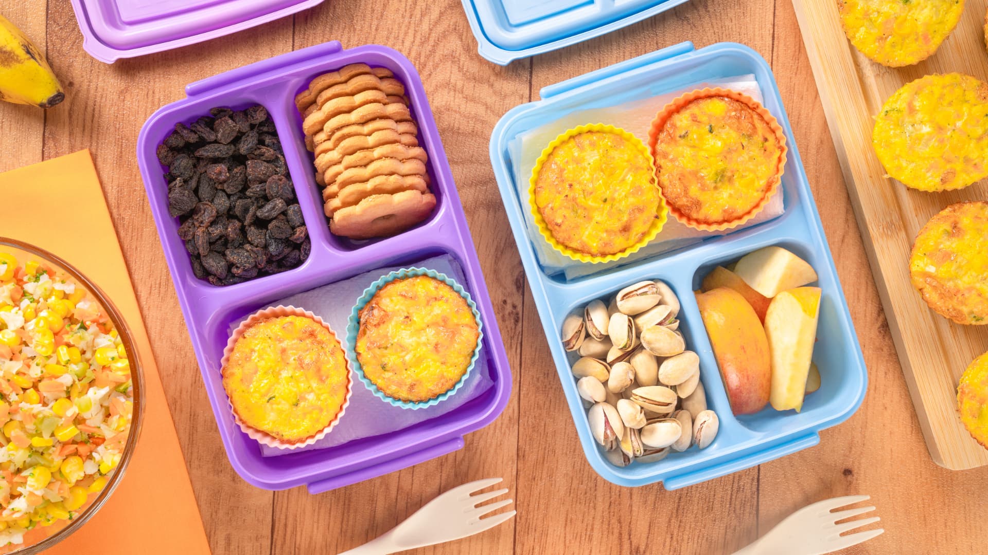 Loncheras con muffins de huevo y verduras, pasitas, galletas, pistaches y manzana, vista cenital