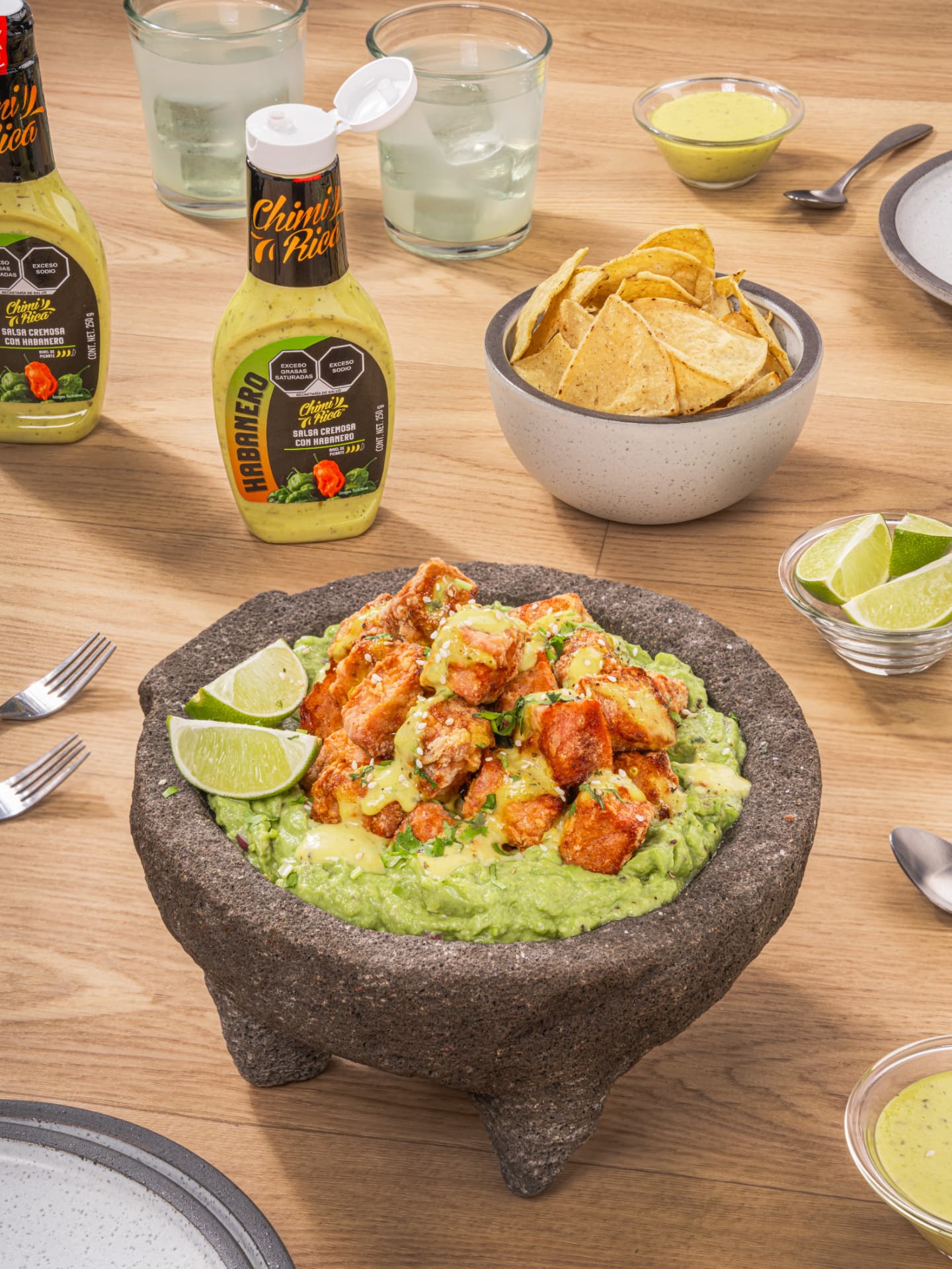 Molcajete con guacamole y botones crujientes de atún, salsa de habanero y limones