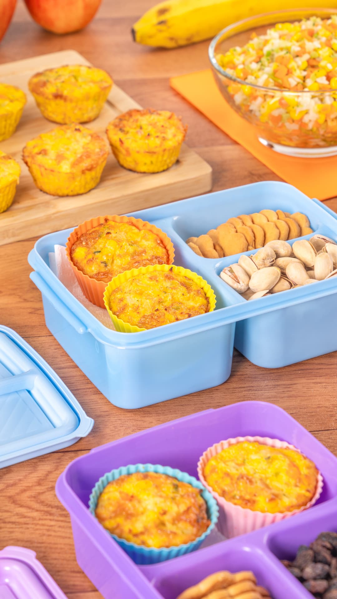 Muffins de huevo con verduras, pistaches y fruta sobre mesa de madera